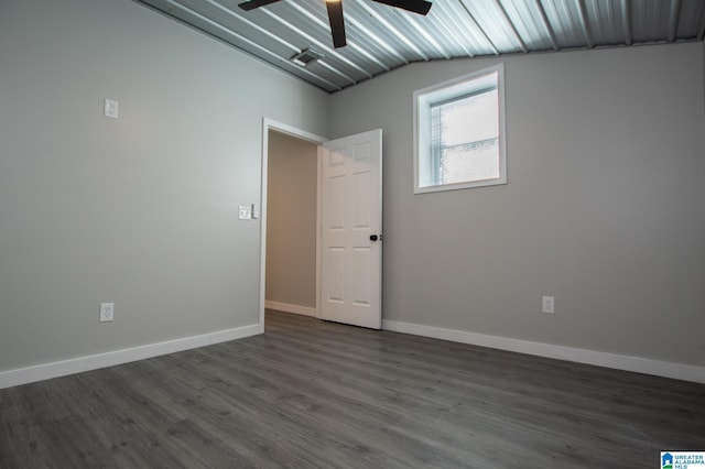 spare room featuring dark wood-type flooring, ceiling fan, and vaulted ceiling