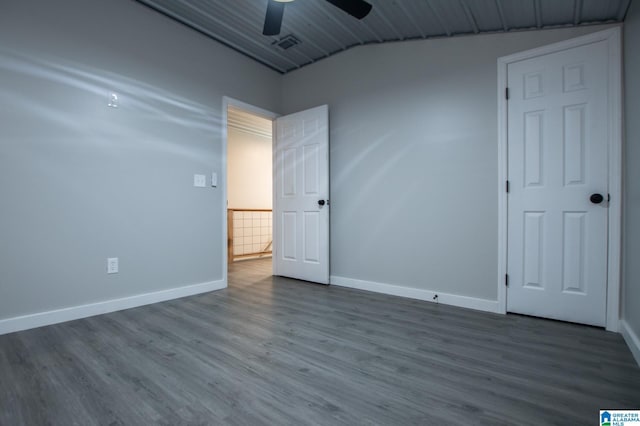 spare room with hardwood / wood-style flooring, vaulted ceiling, and ceiling fan