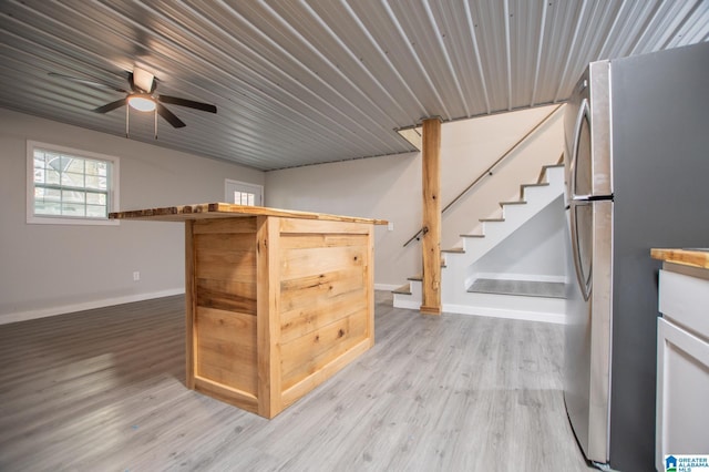 kitchen with light hardwood / wood-style floors, stainless steel refrigerator, and ceiling fan