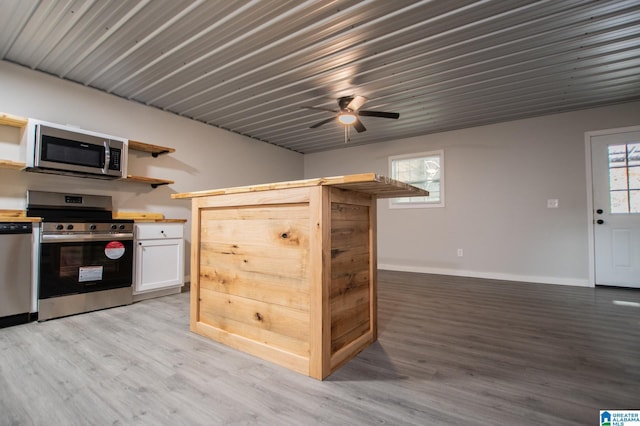 kitchen featuring stainless steel appliances, white cabinetry, hardwood / wood-style floors, and ceiling fan