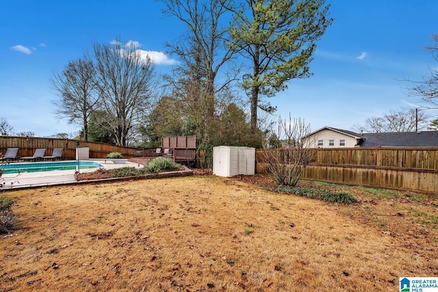 view of yard featuring a storage shed and an empty pool