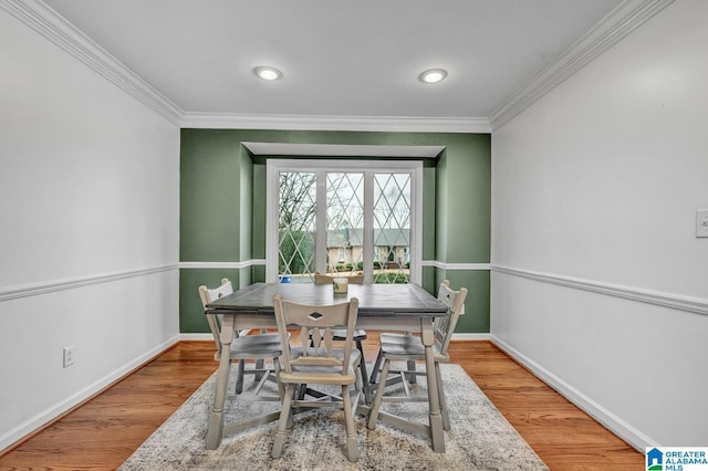 dining area with crown molding and hardwood / wood-style floors