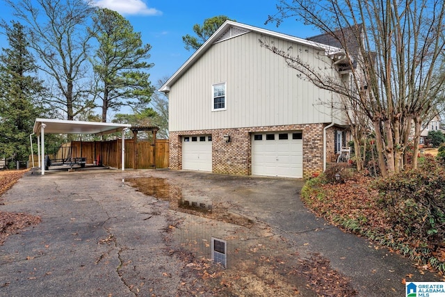 view of side of home featuring a garage and a carport