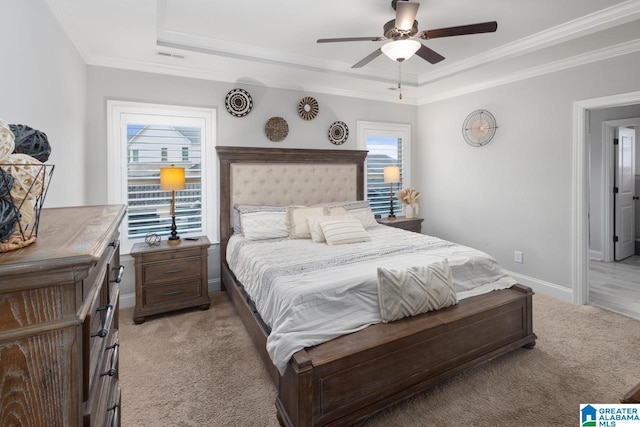 carpeted bedroom featuring ornamental molding, ceiling fan, and a tray ceiling