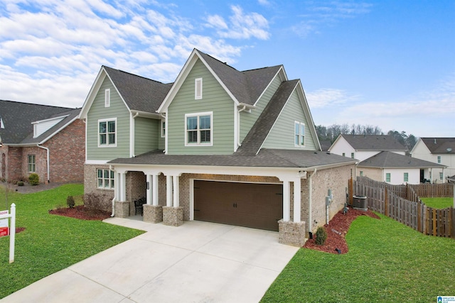 view of front of property with a garage, central AC, and a front yard