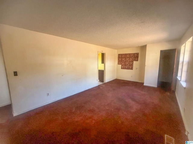 unfurnished room featuring carpet floors and a textured ceiling