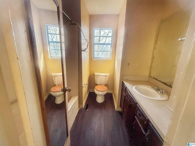 full bathroom with vanity, wood-type flooring, tub / shower combination, and toilet