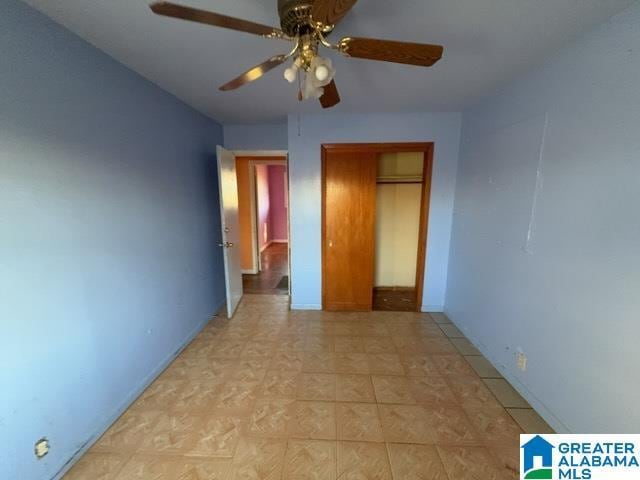 unfurnished bedroom with a closet, a ceiling fan, and baseboards