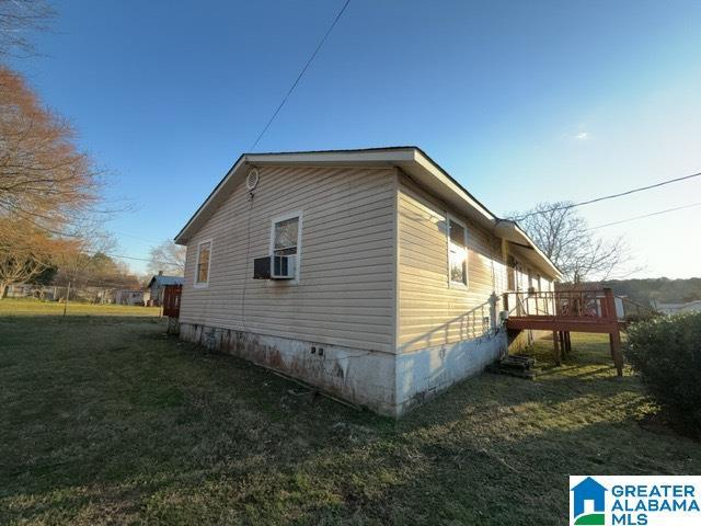 view of property exterior with crawl space, a yard, and a wooden deck