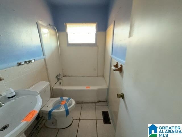 bathroom featuring toilet, tile patterned flooring, and a sink