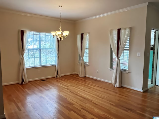 unfurnished dining area with crown molding, wood-type flooring, and an inviting chandelier