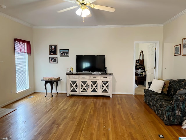 living room with crown molding, ceiling fan, and light wood-type flooring