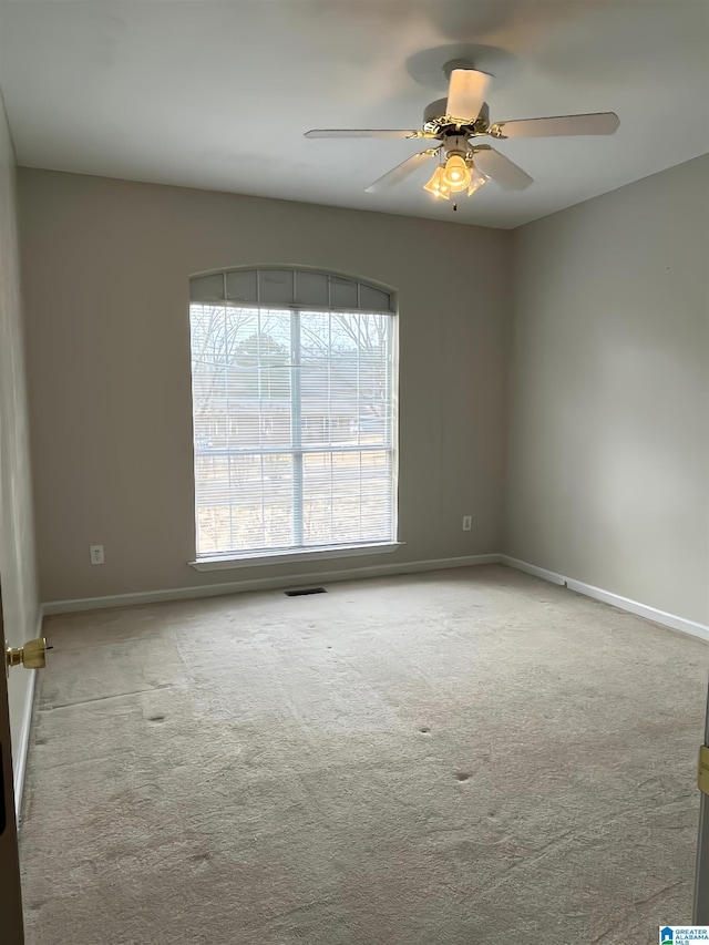 empty room featuring light colored carpet and ceiling fan