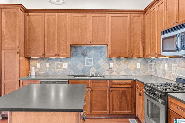 kitchen featuring a sink, dark countertops, brown cabinets, and stainless steel appliances