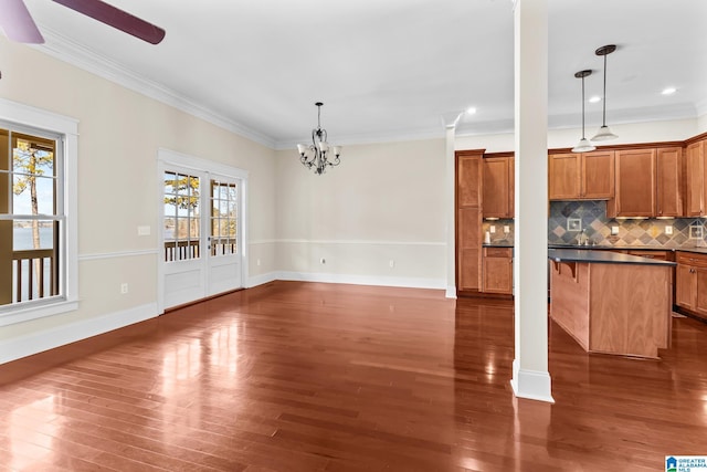 interior space with tasteful backsplash, decorative light fixtures, crown molding, and dark hardwood / wood-style floors