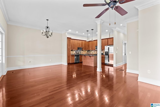 unfurnished living room featuring ornamental molding, dark hardwood / wood-style flooring, ceiling fan with notable chandelier, and ornate columns