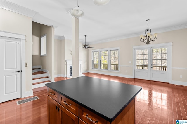 kitchen with a fireplace, dark countertops, wood finished floors, and visible vents