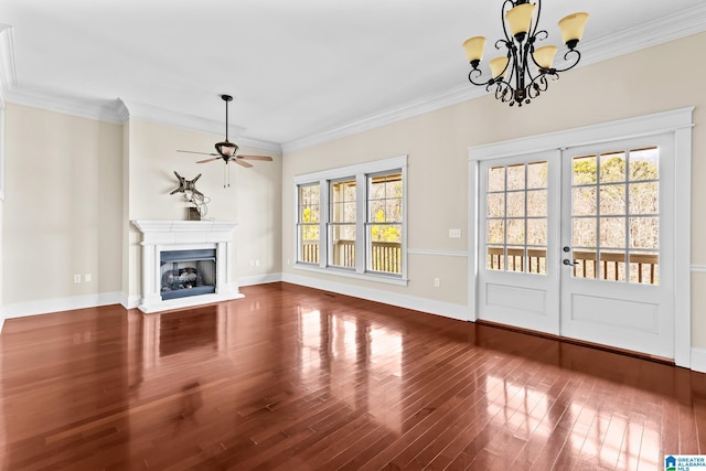 unfurnished living room featuring hardwood / wood-style flooring, ornamental molding, ceiling fan with notable chandelier, and french doors