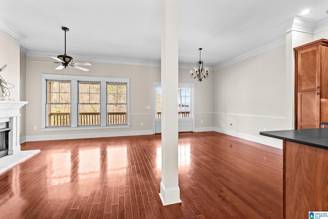 unfurnished living room with crown molding, ceiling fan with notable chandelier, and dark hardwood / wood-style floors