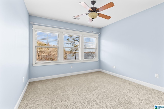 spare room featuring carpet flooring, baseboards, and visible vents