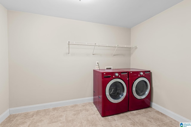 washroom with laundry area, separate washer and dryer, and baseboards