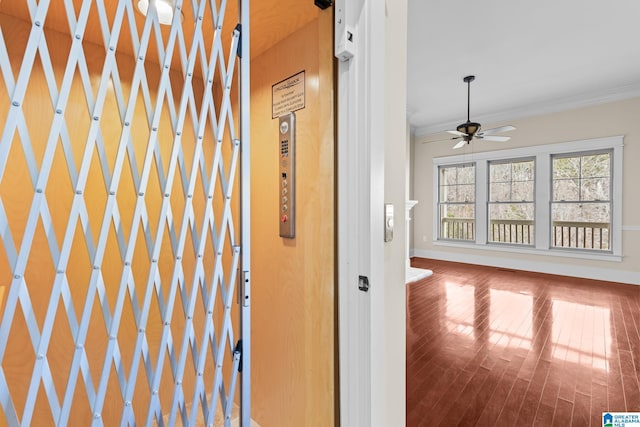 interior space featuring crown molding, elevator, ceiling fan, and hardwood / wood-style flooring