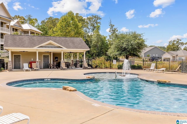 pool with a patio, fence, and ceiling fan