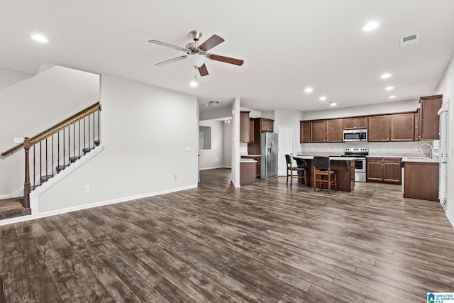 unfurnished living room featuring ceiling fan, sink, and dark hardwood / wood-style flooring