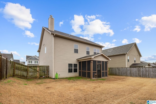 rear view of house featuring a yard and a sunroom