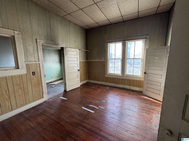 unfurnished bedroom featuring hardwood / wood-style floors and wood walls