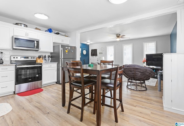 kitchen with ceiling fan, light hardwood / wood-style flooring, stainless steel appliances, and white cabinets