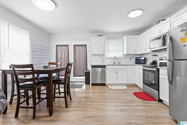 kitchen with appliances with stainless steel finishes, sink, and white cabinets