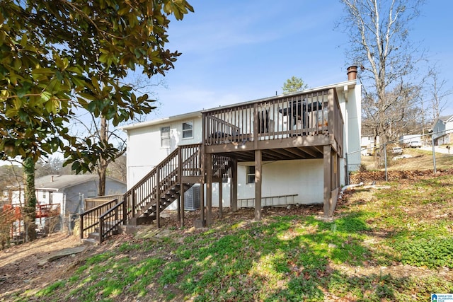 rear view of house featuring a wooden deck, a lawn, and cooling unit