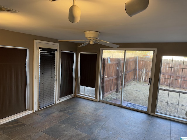 unfurnished room featuring ceiling fan and a healthy amount of sunlight