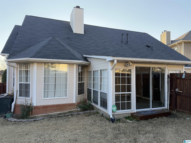 rear view of property with a yard and a sunroom