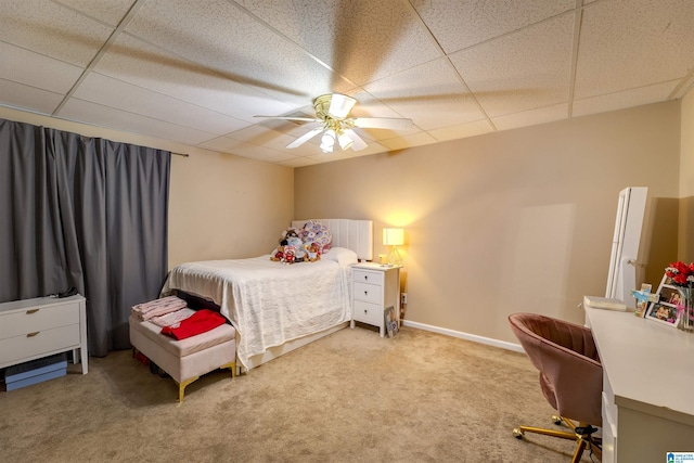 bedroom featuring a drop ceiling, ceiling fan, and carpet