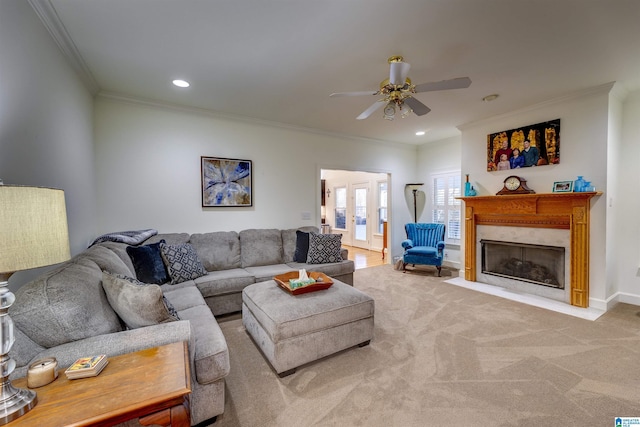 carpeted living room with a fireplace, ornamental molding, french doors, and ceiling fan