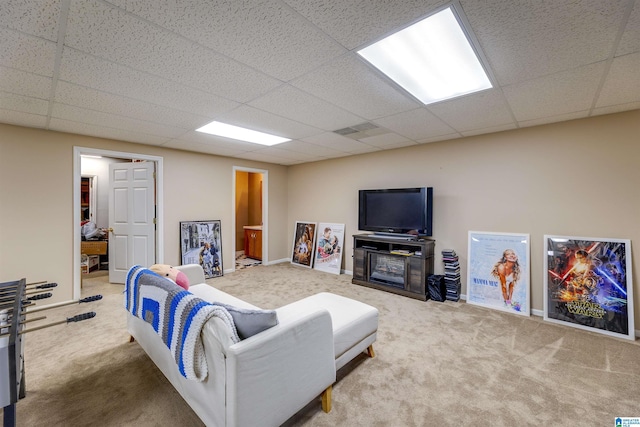 carpeted living room with a drop ceiling