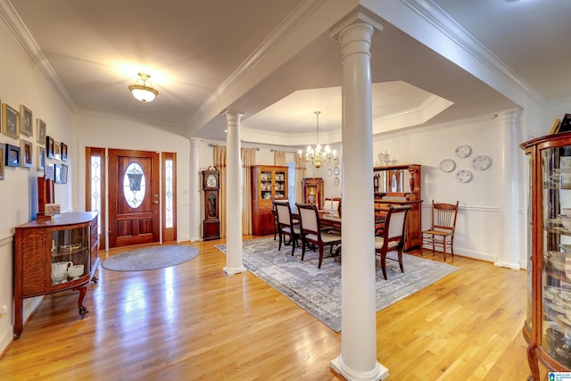 entryway with ornate columns, ornamental molding, a chandelier, and light hardwood / wood-style flooring