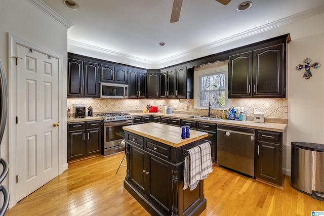 kitchen featuring a kitchen island, wood counters, sink, stainless steel appliances, and light hardwood / wood-style flooring