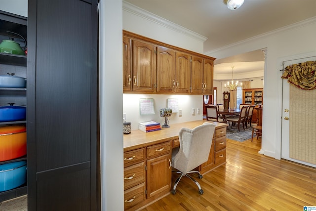 office with crown molding, light hardwood / wood-style flooring, built in desk, and a chandelier