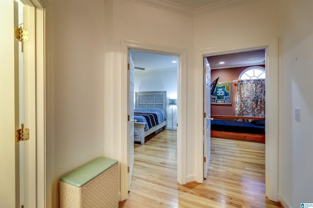 corridor with crown molding and light hardwood / wood-style flooring