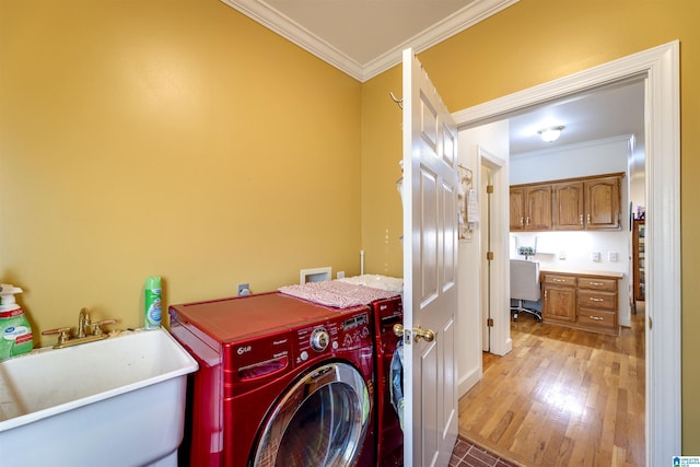 washroom with crown molding, sink, independent washer and dryer, and light hardwood / wood-style flooring