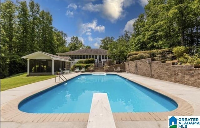 view of swimming pool featuring a gazebo and a diving board