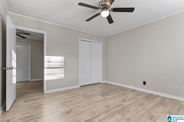 unfurnished bedroom with ornamental molding, ceiling fan, light hardwood / wood-style floors, and a closet