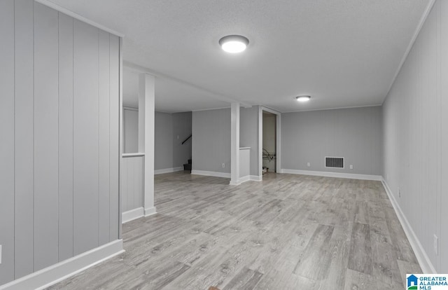 basement with light hardwood / wood-style flooring and a textured ceiling