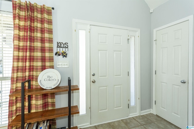 tiled entrance foyer featuring lofted ceiling