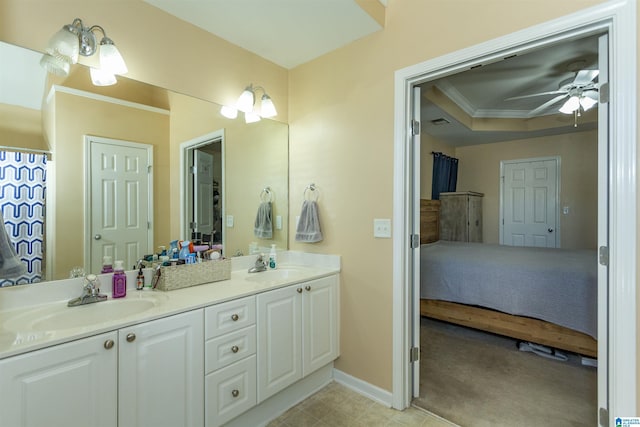 bathroom featuring ornamental molding, vanity, ceiling fan, and a tray ceiling