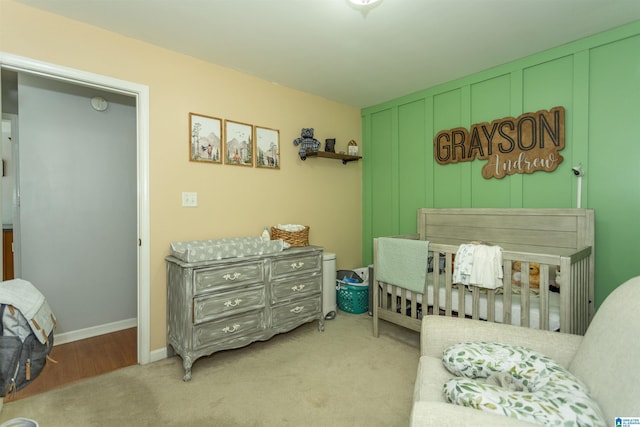 bedroom featuring light carpet and a crib