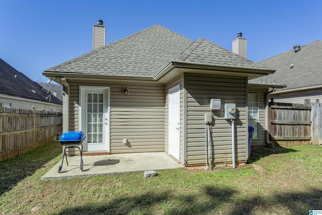 rear view of property with a patio and a lawn